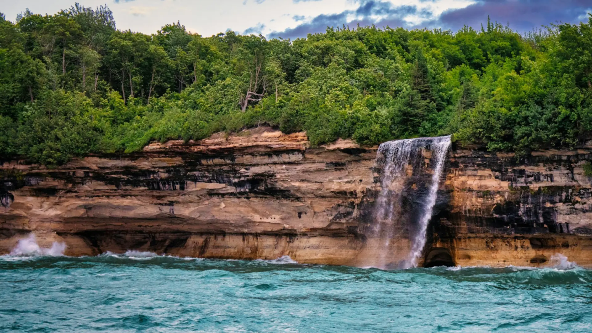 De Spray Falls storten zich in Lake Superior, aan de voet van de zandsteenkliffen van Pictured Rocks, Michigan — Rochester