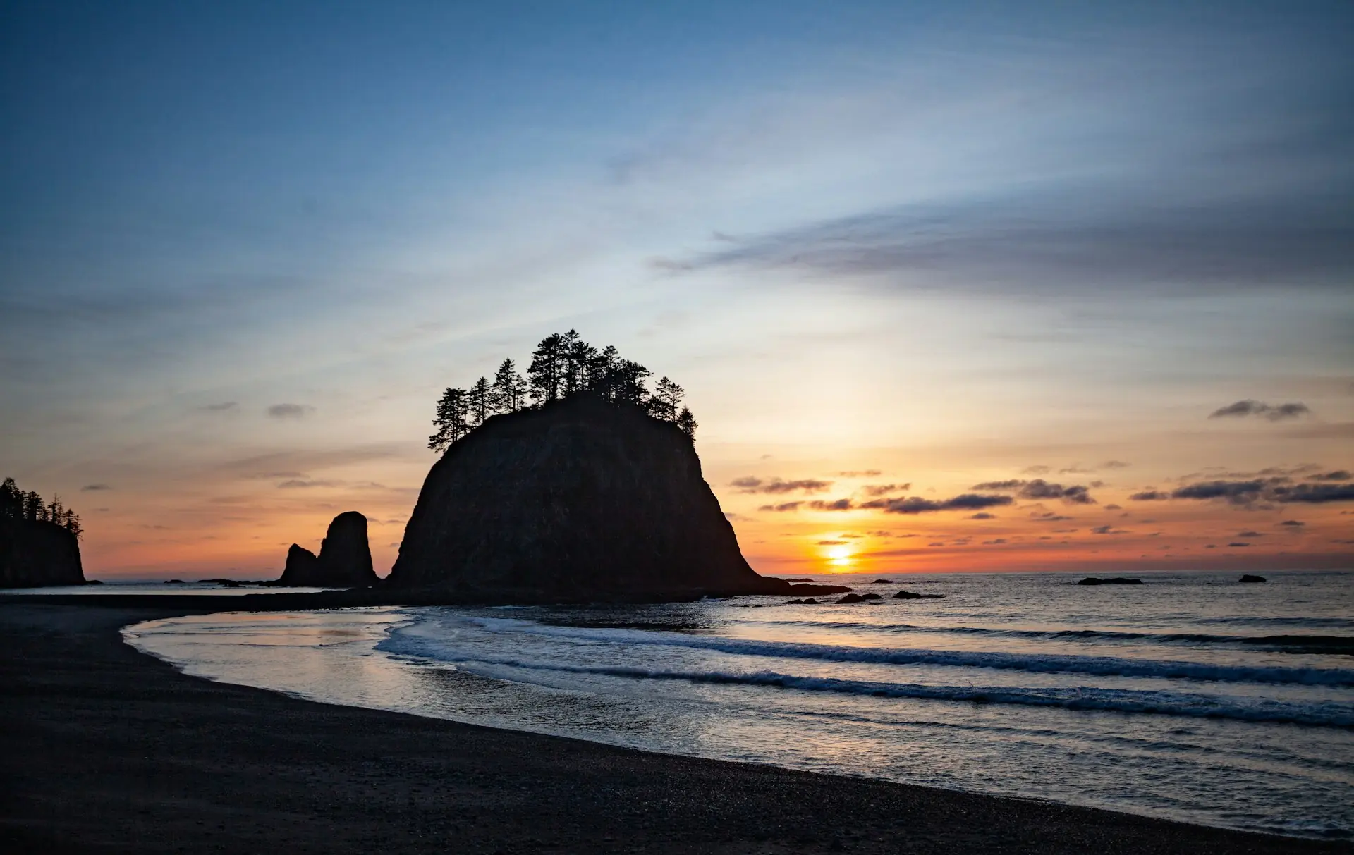 Zonsondergang bij Rialto Beach, in de staat Washington, met een rotseilandje vol naaldbomen. — Tacoma